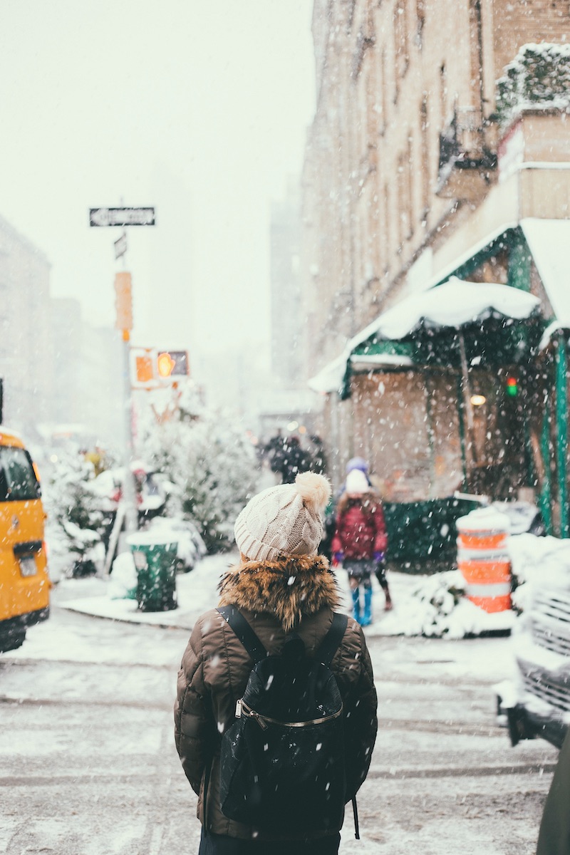 Frau von hinten an Ampel im Schnee