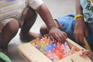 Kinderhand sucht sich bunte Malkreise aus einem Karton